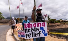People stand with signs waiting for the arrival of Joe Biden in Lahaina, Hawaii, on 21 August. 