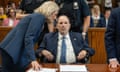 a woman leans down to talk to a man seated in court