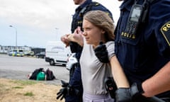 Greta Thunberg smiles slightly as she is carried away by Malmö police