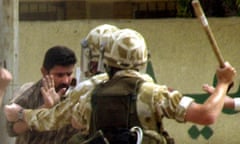 British Army soldiers, part of a 'snatch squad', move in to detain an Iraqi man during a violent protest in the southern Iraq city of Basra 29 March 2004.