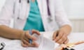 Close-up hands of woman doctor writing a prescription