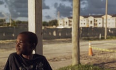 boy outside in the sun with a construction scene behind him