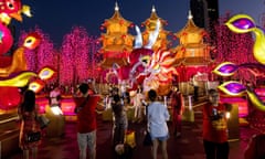 People take photos in front of a festive Chinese display outside a shopping mall in Bangkok.