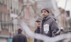 A homeless man wears a contactless payment jacket from Helping Heart. 