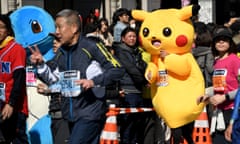 A runner wearing a Pikachu-costume (2nd R) runs past the Ginza shopping district during the Tokyo Marathon 2017 in Tokyo on February 26, 2017. / AFP PHOTO / TOSHIFUMI KITAMURATOSHIFUMI KITAMURA/AFP/Getty Images