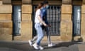 A couple wearing face masks walk through the centre of Newcastle.