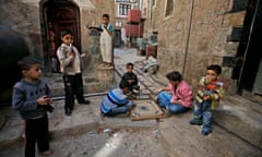 Boys play with toy guns, as others enjoy a match of the board game, carrom, in the Yemeni capital of Sana’a, one of the world’s oldest continually inhabited cities.