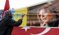 A protestor reacts in front of a poster<br>Istanbul, TURKEY:  A protestor reacts in front of a poster of Turkish novelist Elif Shafak during a demonstartion outside the court during Shafak's trial 21 September 2006, in Istanbul. Shafak hailed Thursday her swift acquittal in a trial over a book about the masscares of Armenians, but said she was alarmed by what she described as a newly-emerging "culture of lynching" against dissident views in Turkey. AFP PHOTO/MUSTAFA OZER  (Photo credit should read MUSTAFA OZER/AFP/Getty Images)