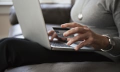 A woman on a laptop holding a credit card