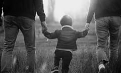 Child walking hand in hand with adults