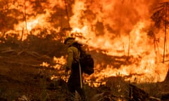 a firefighter walks near a fire