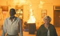 Richard Roundtree and June Squibb walk away from a bin on fire inside a house, in Thelma.