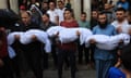 Relatives carry the bodies of children from the Abu Quta family killed by Israeli strikes on Rafah, during their funeral.