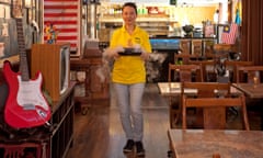 The interior of Med Salleh and a staff member carries the shaved ice dessert, smoking from dry ice