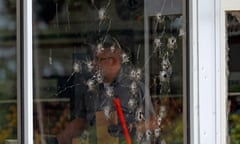 A bullet-scarred window and a police officer.