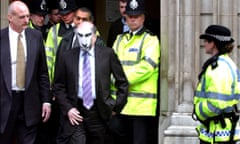 Boris Berezovsky. Leaves Bow Street Magistrates Court, wearing a mask depicting Vladamir Putin, the Russian president. London. 02-04-2003. Photograph by Martin Godwin.