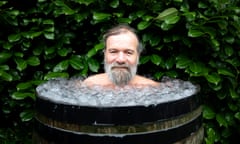 A middle-aged man in a barrel full of iced water