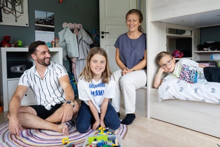 A family sits in a child’s bedroom.