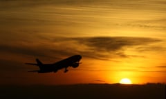 Plane taking off at sunset