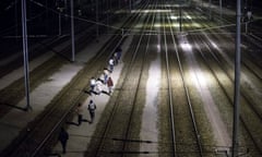 Refugees run on the shuttle tracks