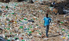 A file picture dated 13 April 2010 shows a boy from Senegal walking along a polluted beach strewn with predominantly plastic bottles in the village of Ngor, Dakar, Senegal.