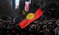 A person holds up the indigenous flag during the annual Victorian NAIDOC  march