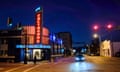 a street corner is lit up at night