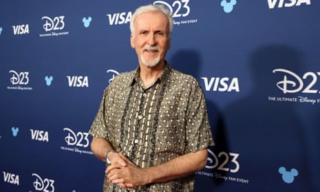 A man wearing a patterned shirt smiles and folds his hands together at an event