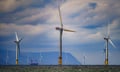 A dozen wind turbines stand in the sea at an offshore wind farm in Wales.