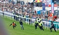 A man gets on to the race track at Epsom, pursued by police and a steward