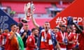 Sam Lavelle lifts the trophy at Wembley after Morecambe secured a place in the third tier for the first time in their history.