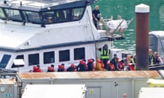 A group of people disembark from a Border Force vessel in Dover.