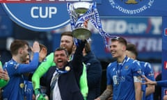 The St Johnstone manager, Callum Davidson, hoists the trophy aloft after their Scottish League Cup triumph.