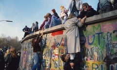 women climb the  Berlin Wall on November 10, 1989 in Berlin, Germany