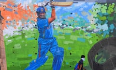 A man wearing a mask walks past a mural of former Indian cricketer Sachin Tendulkar in Mumbai