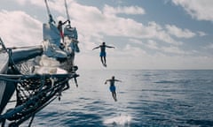 Two men jumping into sea from the prow of a sailing ship