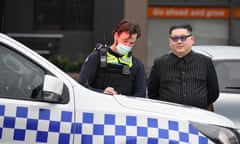 A man dressed as North Korea’s leader Kim Jong-un is spoken to by a Victorian police officer