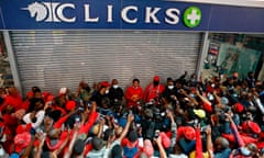 Julius Malema with a group of supporters outside a shuttered Clicks store