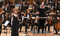 conductor Simon Rattle, soprano Siobhan Stagg and the LSO look up towards the London Symphony Chorus in the balcony at the Barbican.