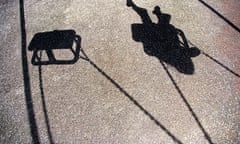 The shadow of a young girl or boy playing on a swing