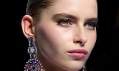 Model wearing light blush and big earrings