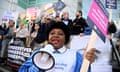 A woman uses a megaphone as nurses and other medical professionals protest over pay and conditions in London in February