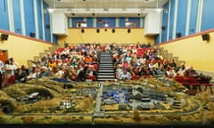 An audience sitting behind a huge model of a town.