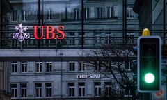 A traffic light signals green in front of the logos of the Swiss banks Credit Suisse and UBS in Zurich, Switzerland