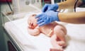 Moments After Being Born<br>A newborn boy is checked over by a midwife in a hospital to ensure he's healthy.