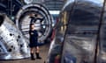 Lindy Lee standing among large metal cylinders