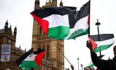 Demonstrators wave Palestinian flags as they protest in Parliament Square in London on 21 February