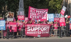 People hold banners and placards to urge support for assisted dying