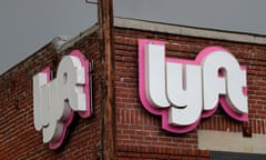 Lyft's logo hangs from the side of a brick building.