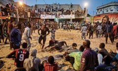 In this image released by World Press Photo titled "The Gris-gris Wrestlers of Senegal" by photographer Christian Bobst which won the second prize Sports Stories category shows a tournament in the Adrien Senghor arena leaning towards the end. The wrestling fights take place in the late evenings when temperatures drop. Dakar, Senegal, 28 March 28, 2015. (Christian Bobst, World Press Photo via AP)